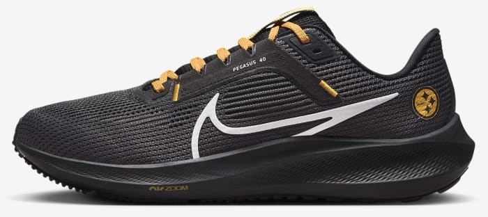 Side view of black and yellow Nike running shoes.